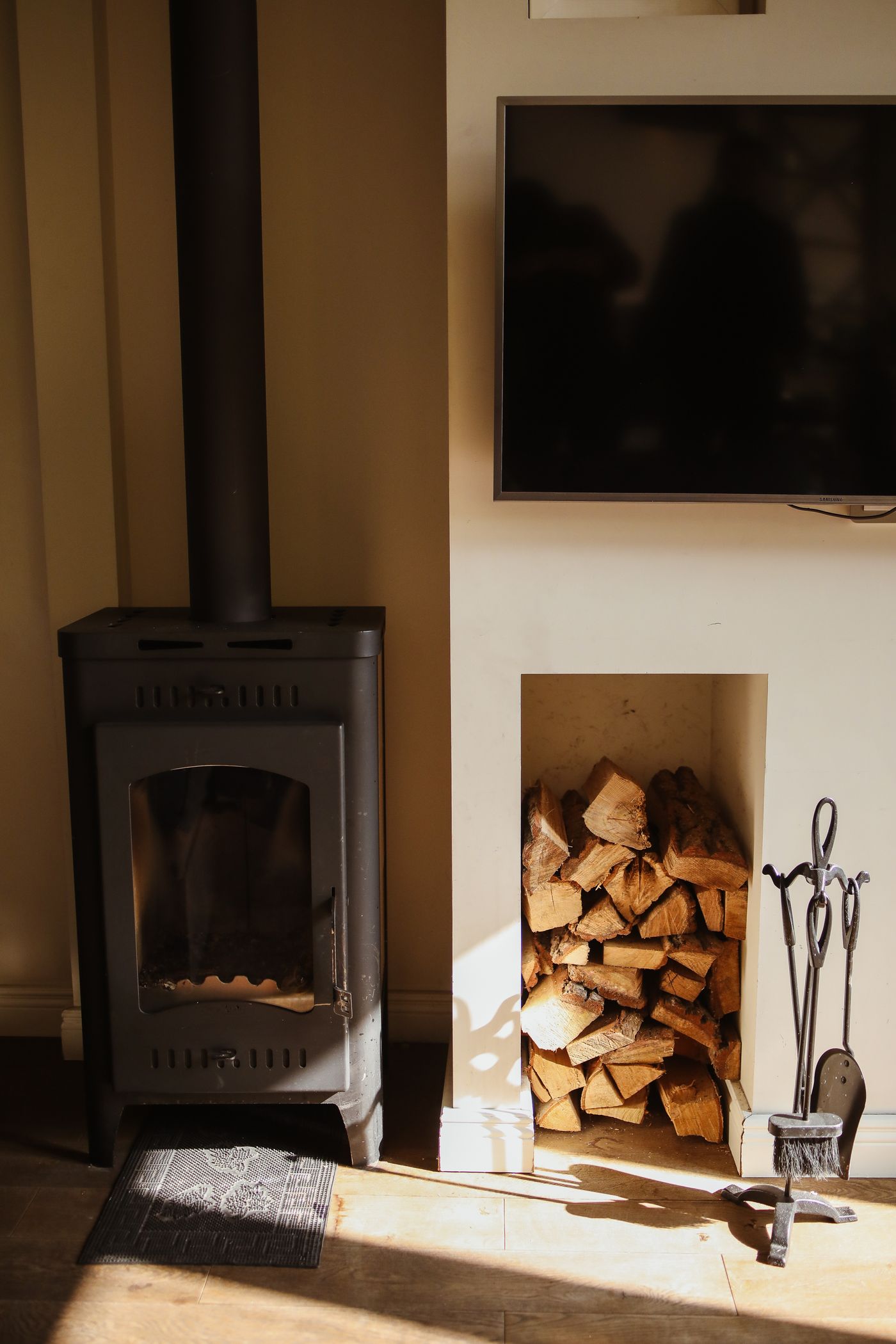 A warm fireplace laid with logs